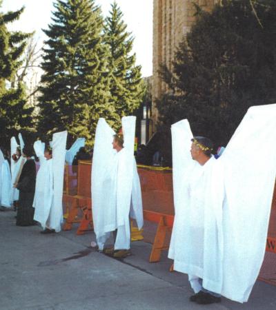 Supporters of Matthew Shepard's family dressed as angels stand silently to block hateful anti-gay protesters from the Westboro Baptist Church. 